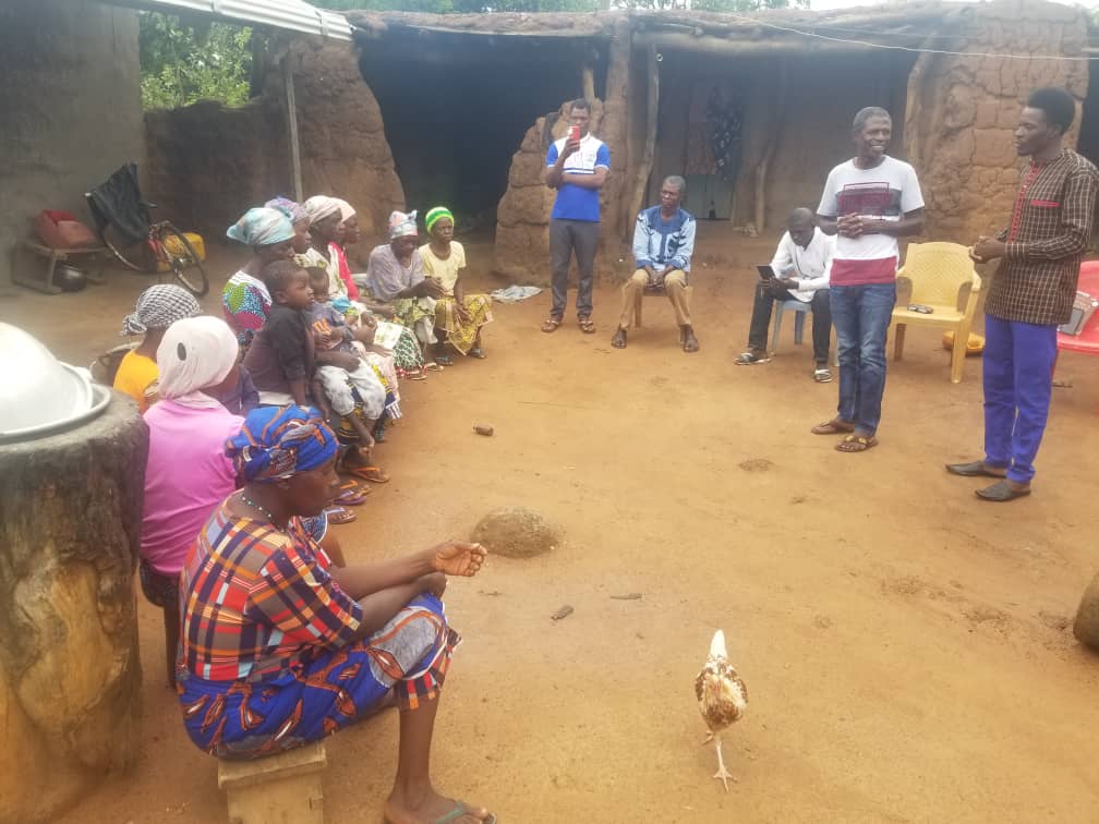 Emmanuel teaches a group of villagers in northern Ghana, while Joshua interprets.