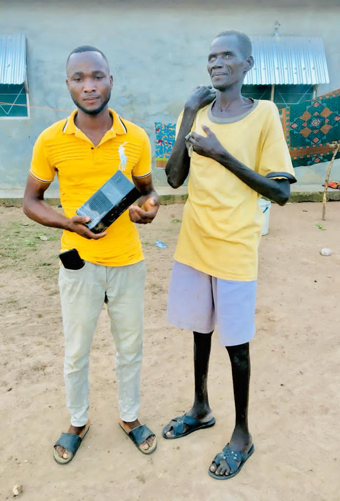 Brother Prince Maando presents an audio bible to Waasaa Jagri, a visually impaired man